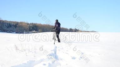 一个骑着山地车的人。 比克正在雪地里推自行车。 多云的冬日，风和雪花轻柔